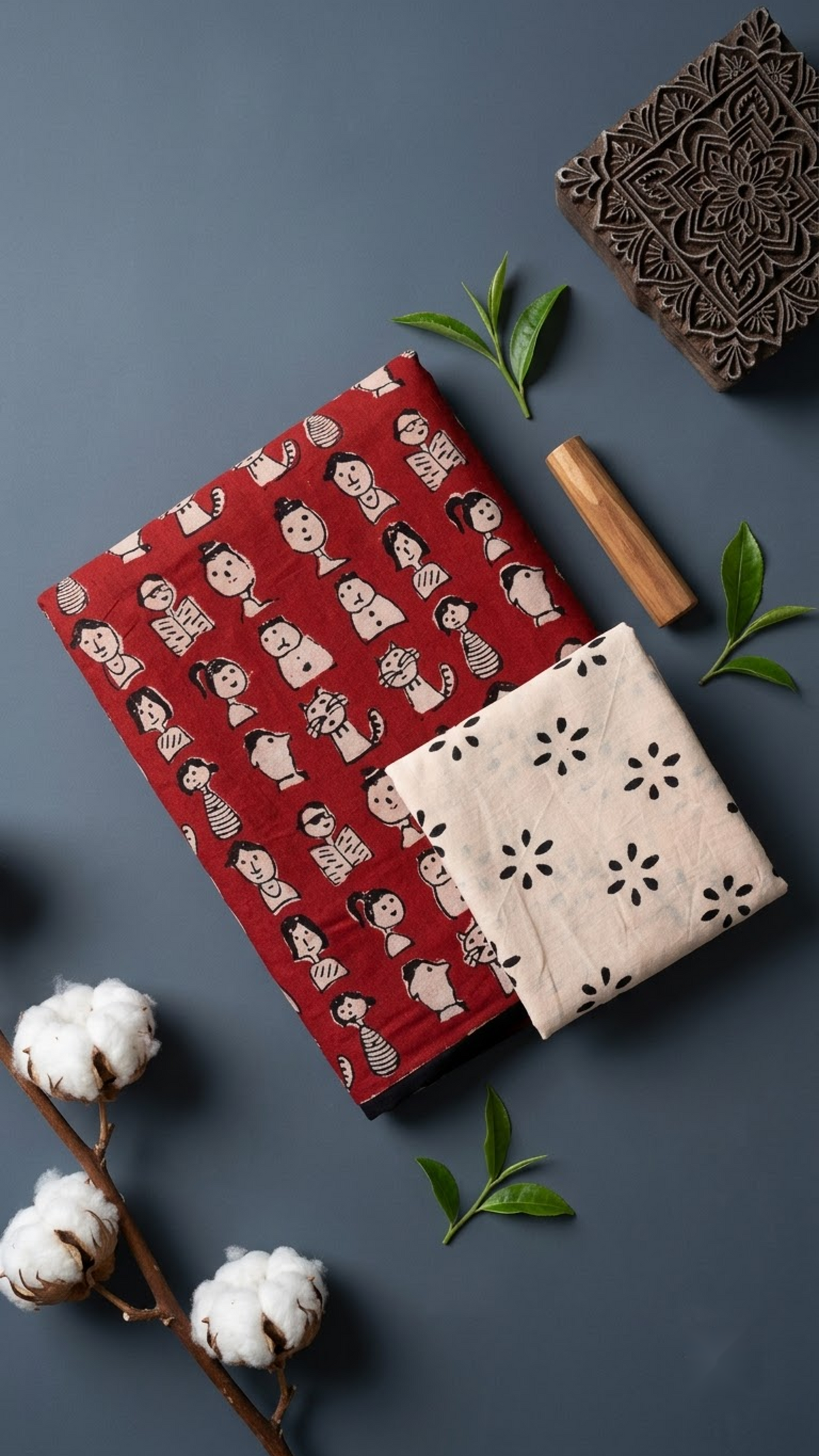 Close detail of ivory character motifs on the red cotton saree with contrasting ivory floral blouse