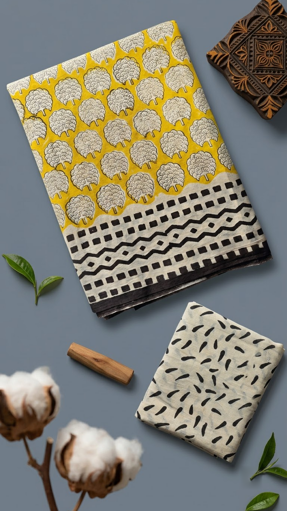 Yellow cotton saree with ivory floral medallions, black geometric border, and ivory black leaf-print blouse piece, shown with the blouse piece in a close detail view