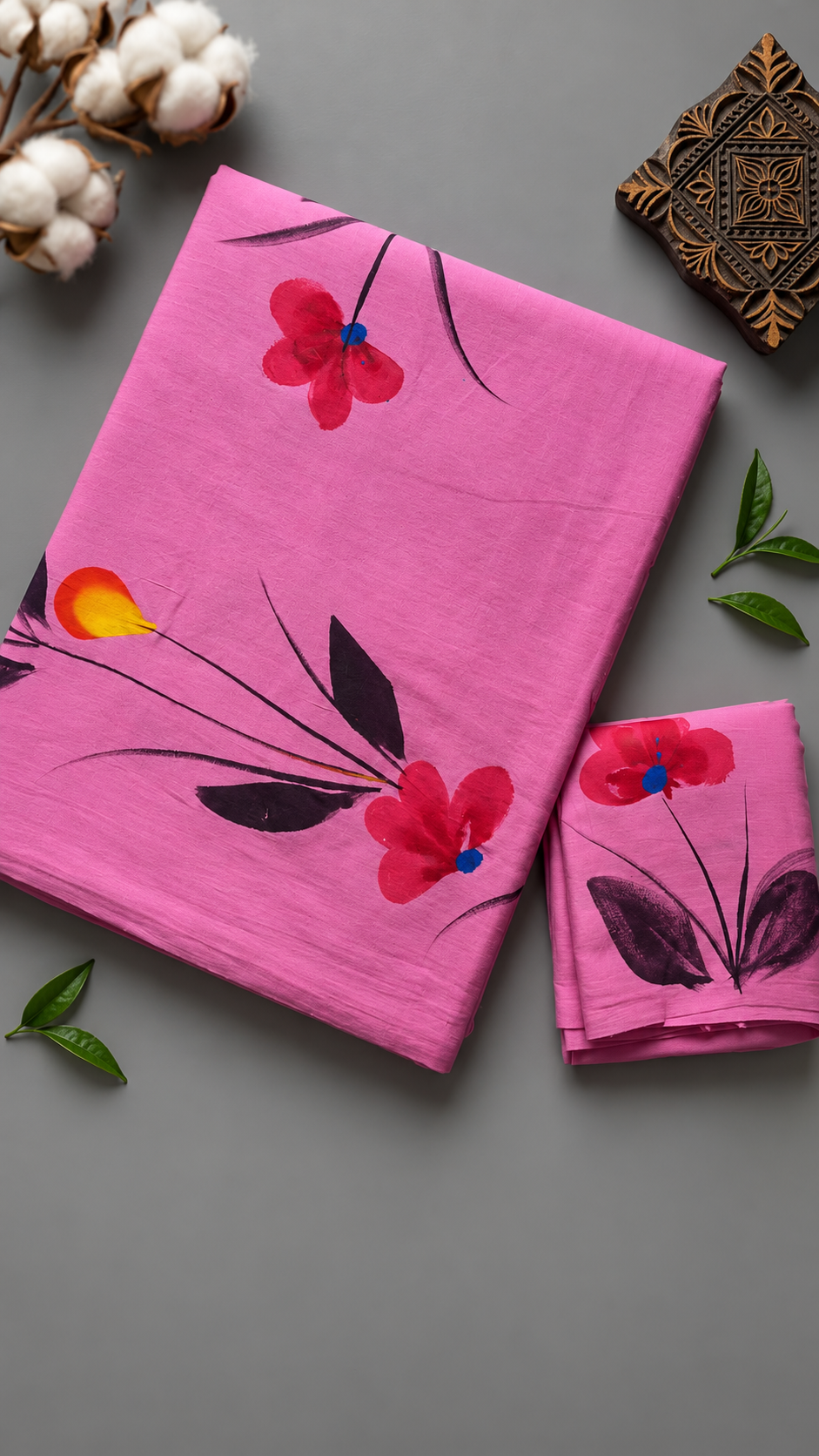 Close detail of red flowers, blue centres, and dark botanical stems on pink cotton fabric with the matching floral blouse piece