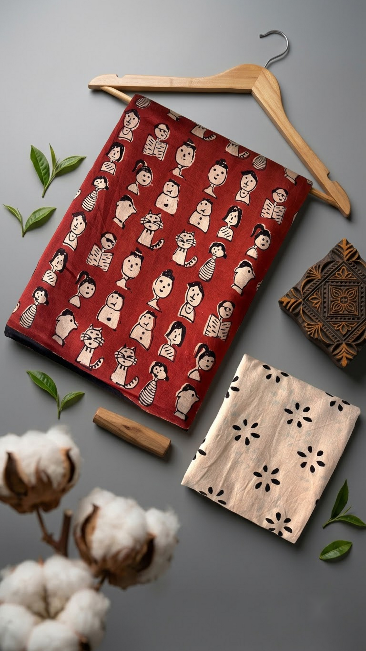 Red character print cotton saree and ivory floral blouse in artisan flatlay with wooden hanger