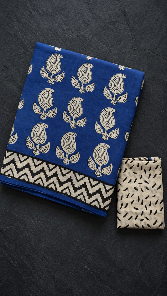 Royal blue paisley cotton saree with black zigzag border, folded on charcoal