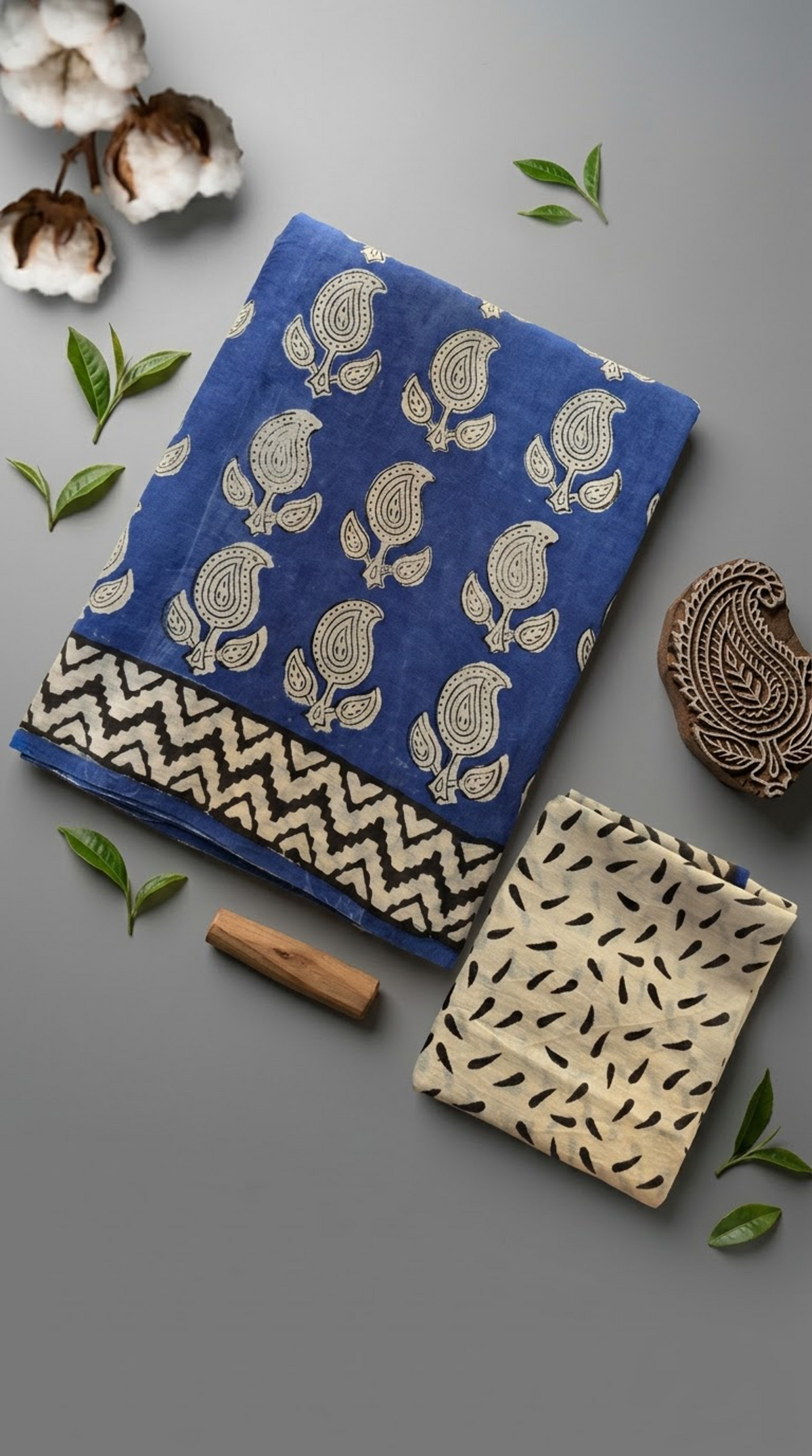 Blue cotton saree with small ivory motifs and a light patterned fabric piece in a styled flat lay