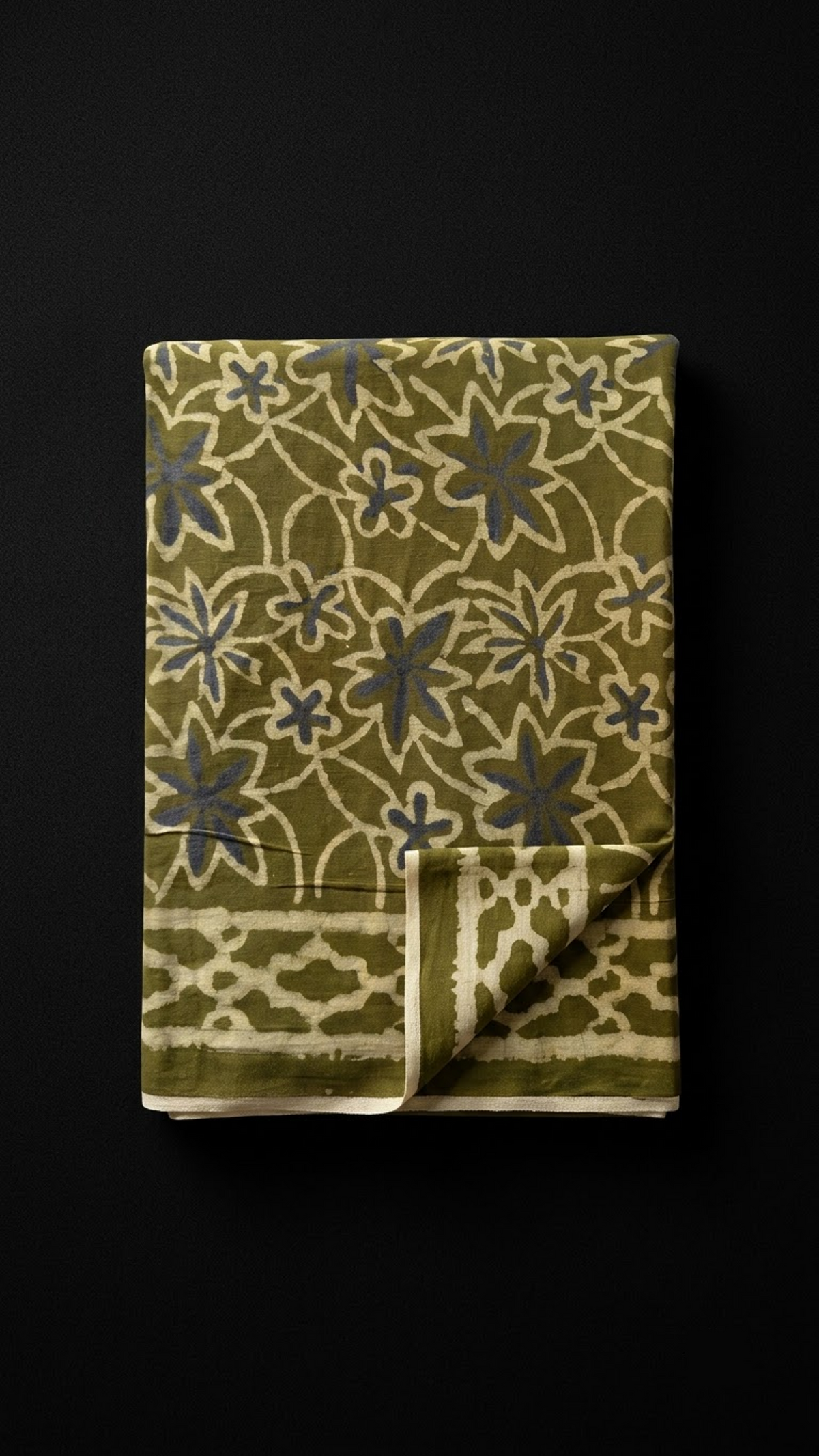 Olive cotton saree with ivory outlined flowers and loop-pattern border, folded on charcoal