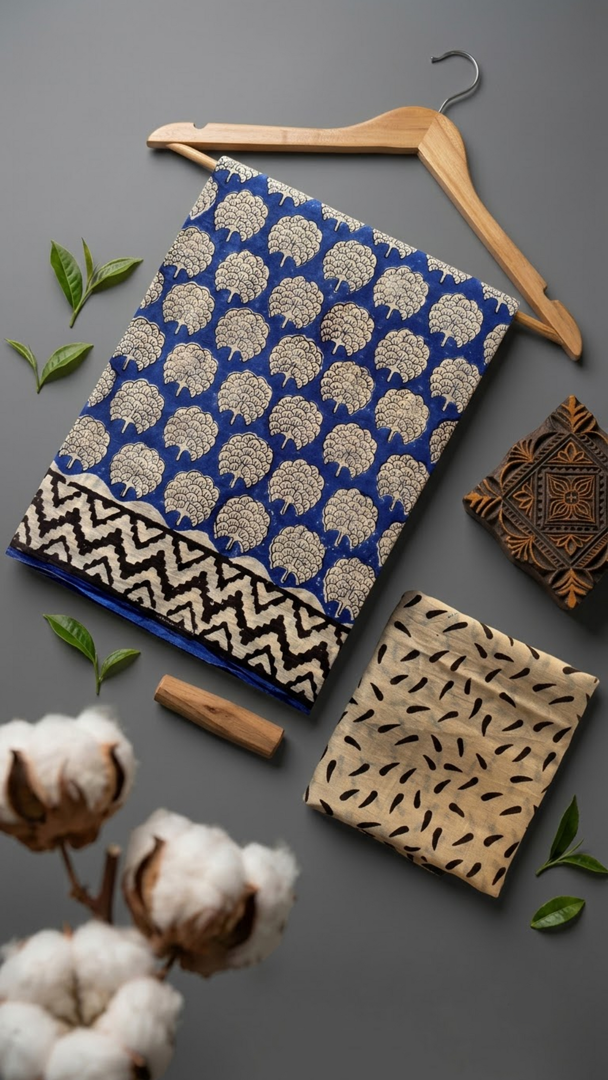 Royal blue floral medallion cotton saree with stepped border and ivory leaf-print blouse piece in a styled flat lay