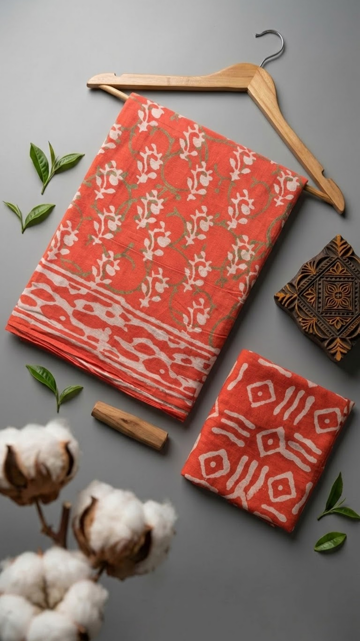 Coral botanical cotton saree with its ivory geometric blouse piece in a styled flat lay