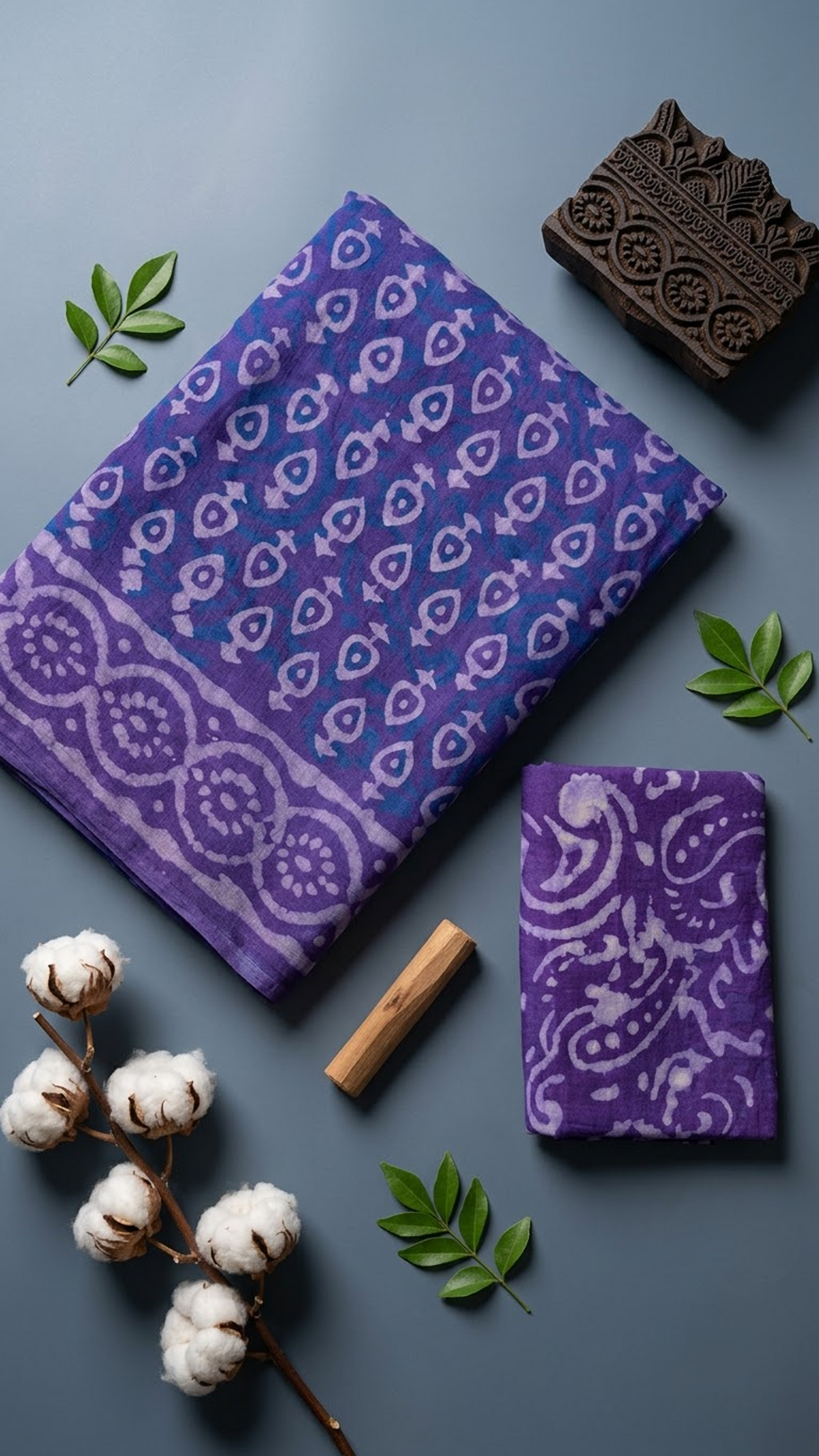 Close detail of light teardrop motifs, blue accents, and the circular border on purple cotton fabric with the paisley blouse piece