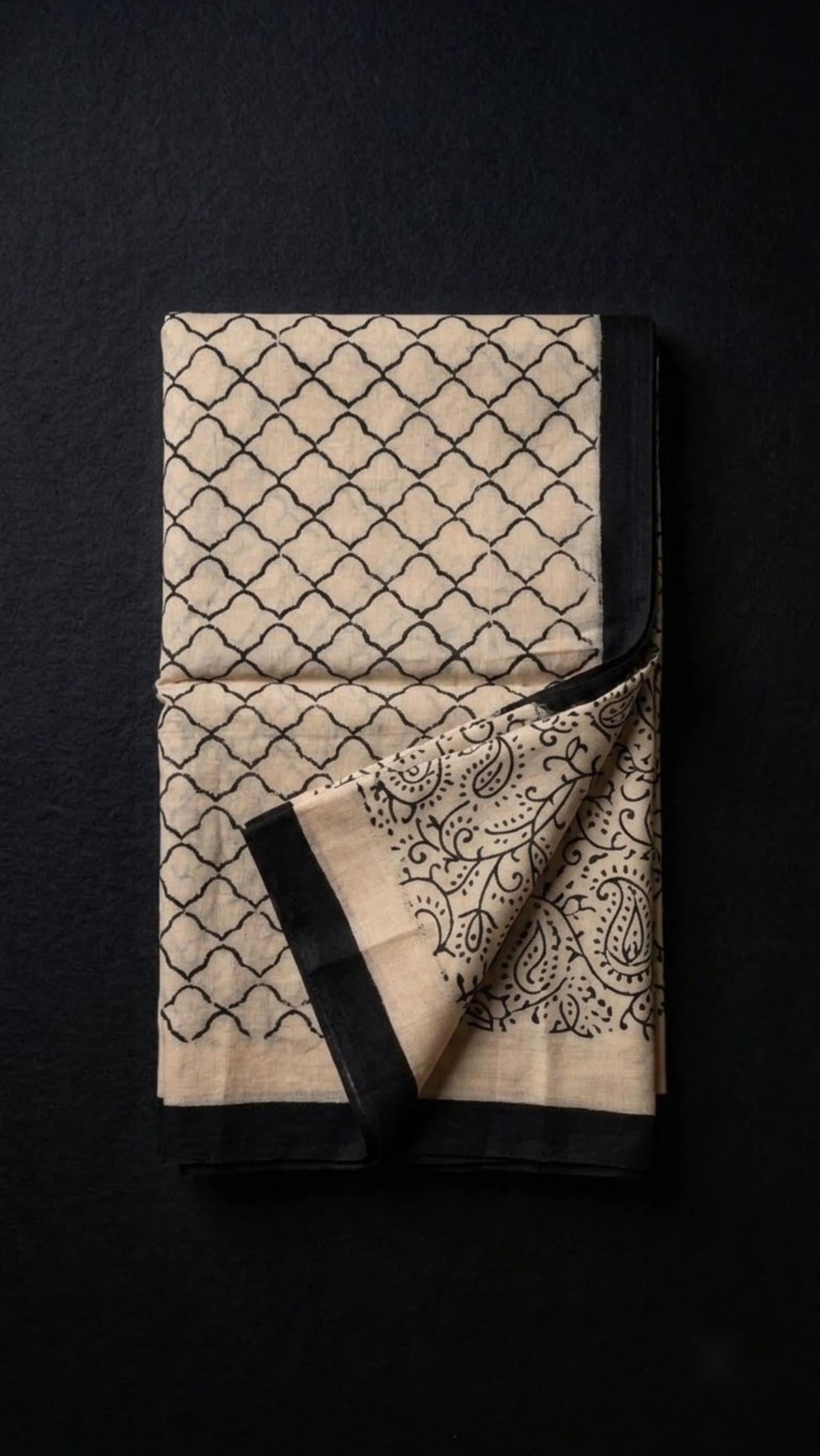Folded ivory lattice cotton saree with blouse piece on a charcoal background
