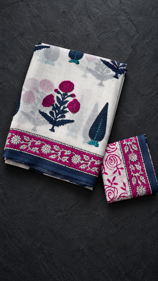 Ivory cotton saree with magenta flowers, navy foliage and teal accents, a magenta floral border with navy edging, and an ivory magenta rose blouse piece, folded on a charcoal background
