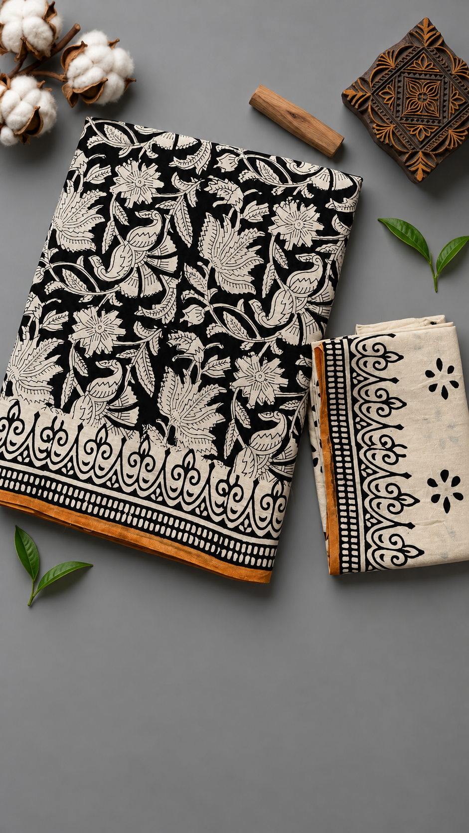 Close detail of ivory bird, floral, and leaf motifs on the black cotton saree and its ornamental border with an ochre edge